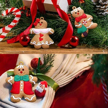 Gingerbread man ornaments hanging on a Christmas tree with red and green decor