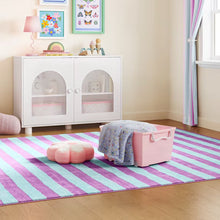 Pink rolling toy storage basket with a blanket draped over the rim