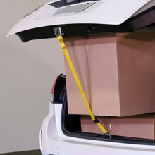 Yellow trunk strap holding a box in open car hatch with hook ends