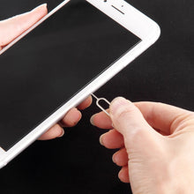 Hand using a metal pry tool to separate a smartphone back panel