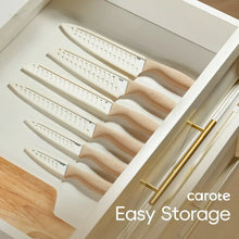 Ceramic kitchen knives stored in a drawer with blade guards and cream handles