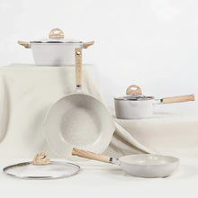 Nonstick cookware set featuring saucepans, frying pans, lids, and light wood handles.