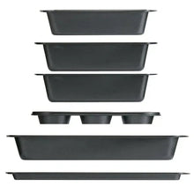 Stack of dark non-stick bakeware pans, including loaf pan and rectangular baking tray