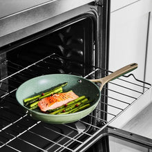 Olive non-stick skillet with speckled surface and long handle on an oven rack