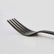 Black stainless steel dinner fork with ridged handle