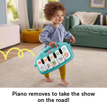 Blue activity playmat with arched piano and removable toy, toddler holding the piano