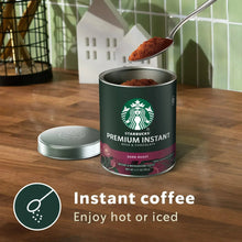 Dark roast instant coffee can with spoonful of coffee powder