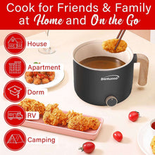 Black electric hot pot cooker on table with house and camping icons
