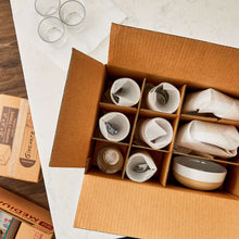 Glass packing kit partitions holding foam-padded glassware in a brown box