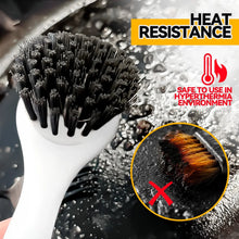 Dish brush with white body and black bristle head, water droplets on bristles