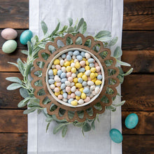Milk chocolate mini eggs in pastel colors in a wreath-style bowl
