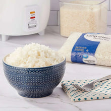 Cooked white rice in patterned bowl with long grain rice bag.