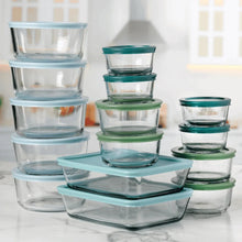 Multi-size glass food storage containers with teal and green lids, stacked together