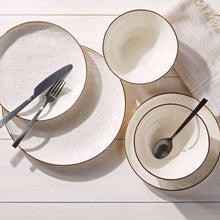 Set of two cream stoneware dinner bowls with dark rims and speckled texture