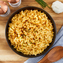 Cooked elbow macaroni in a bowl with sprinkled seasoning