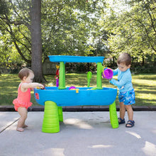 Kids' outdoor splash water table with purple and green play pieces on patio