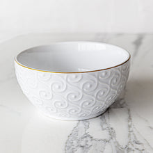 White stoneware bowl with embossed swirl texture and gold rim