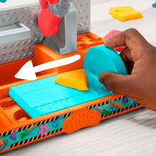 Tool bench work surface with teal platform, yellow clay pieces, and orange base
