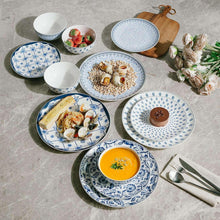 Ceramic dinnerware set with blue-and-white plates and bowls, arranged on tabletop