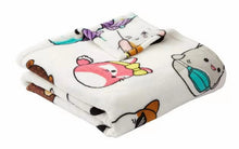 Folded throw blanket with cartoon animal characters in white, teal, and pink