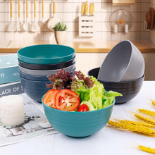 Stacked teal and gray wheat straw dinnerware bowls and cups with salad and wheat pieces