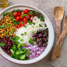 Bowl of basmati rice with vegetables, herbs, beans, and crumbled cheese