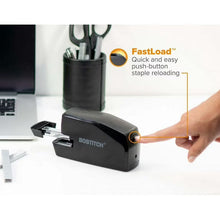 Hand loading staples into dark gray stapler while it rests on a work surface