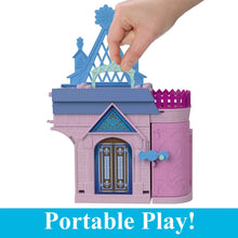 Pink and blue castle dollhouse playset with open front door and hand placing top piece