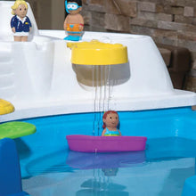 Water table feature with raised yellow spout and floating boat toys