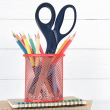 Blue-handled titanium scissors in a mesh cup, with colored pencil tips nearby