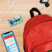 Orbit sweet mint sugar-free gum pack on wooden surface with red pouch nearby