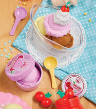 Clear bowl of pretend ice cream with cherry pieces, spoon, and pastel scoops