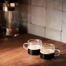 Two cups of black coffee with light crema
