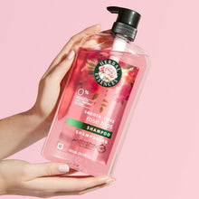 Hand holding rose hips shampoo bottle with black pump and green shampoo label
