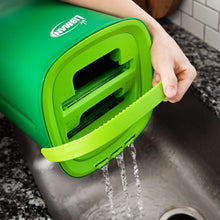 Green wringing chamber releasing water, flat mop with hand compressing
