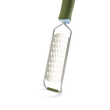 Green handheld box grater with stainless shredding holes and grip handle