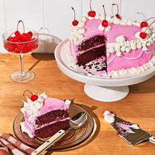 Heart-shaped stoneware baking dish holding a frosted cake slice topped with berries