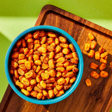 Seasoned toasted corn nuts in a blue bowl on a wooden board