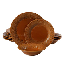 Caramel ceramic plates and bowls stacked, each with raised lace-style medallion trim