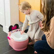 Pink potty training toilet with white seat and black bow on top