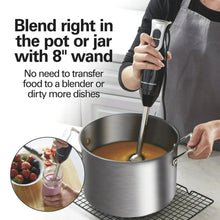 Immersion hand blender in use held above a pot