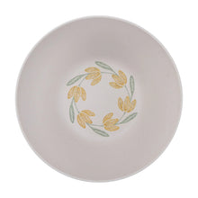 Round salad bowl lid with yellow tulip-style floral wreath on white surface.