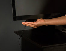 Roku Express HDMI cable being plugged into a TV or media device by hand