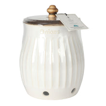 White stoneware onion keeper with ridged sides, wooden knob lid, tag on top