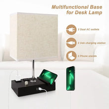 Fabric-shade desk lamp with black charging base showing AC outlets, USB charging, stands
