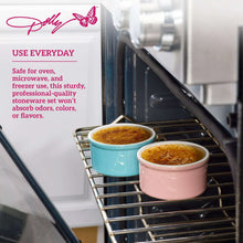 Pink and blue round ceramic ramekins on oven rack with baked contents inside.