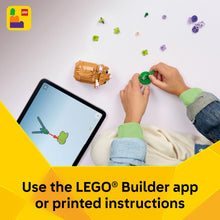 Child placing small LEGO pieces while using a tablet for building