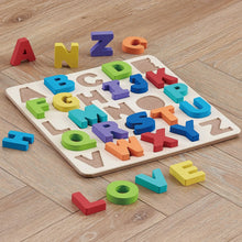 Wooden alphabet puzzle with colorful letter blocks scattered on a board