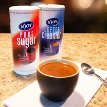 N'Joy coffee creamer canisters with cup of coffee on countertop