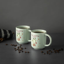Pair of light green ceramic mugs with baby frog in boots and “That’s Showbiz Baby” text
